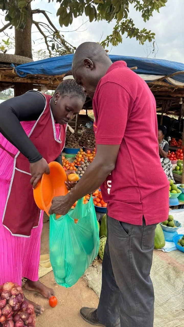People selecting produce at an outdoor market.