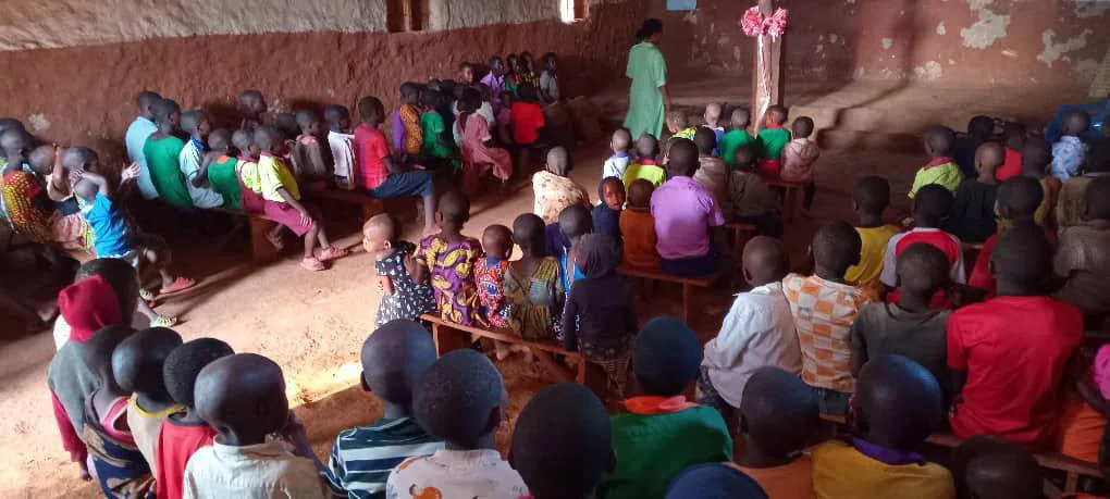 Students and their teacher gathered in a classroom at Isingiro.