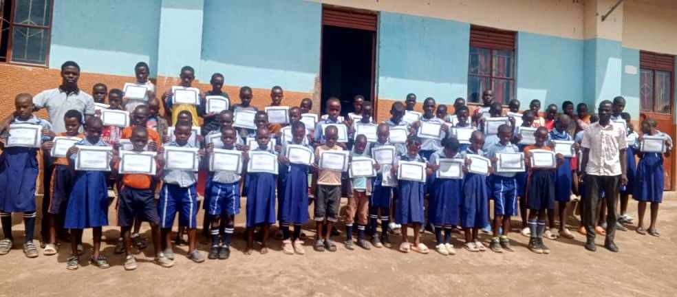 Students standing outside classrooms holding scholarship certificates.
