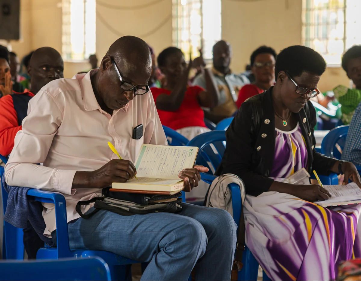 Seated leaders taking notes during a teaching session.