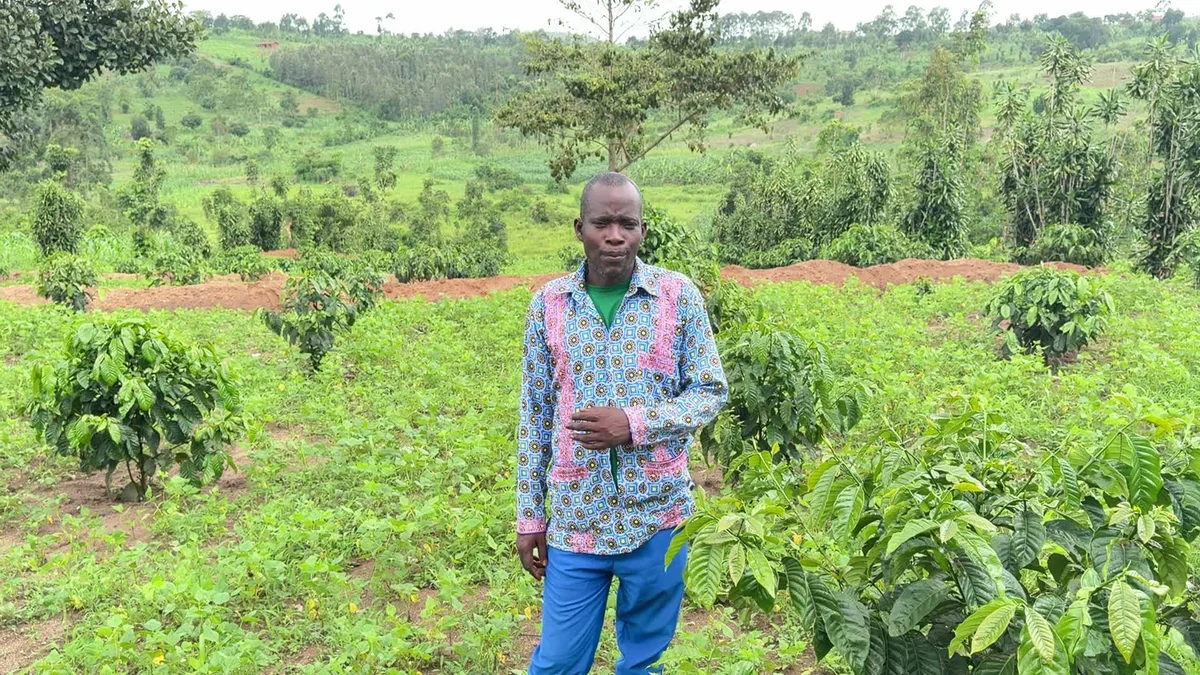 Pastor Joseph standing in his coffee garden.